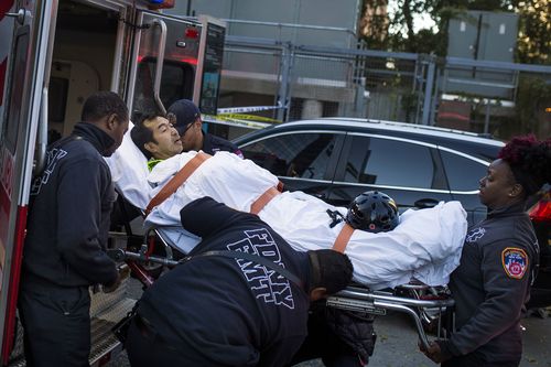 Emergency personnel transport a man on a stretcher. (AP)