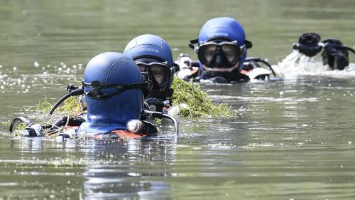 Divers of the French gendarmerie search for evidence in a pond near Pont-de-Beauvoisin, eastern france, on August 30, 2017 after the disappearance of a 9-year-old girl. (AP)