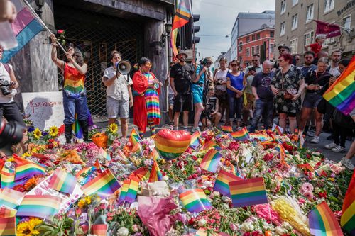 Flowers are left as a spontaneous pride parade arrives at the scene of a shooting in central Oslo, Saturday, June 25, 2022.  