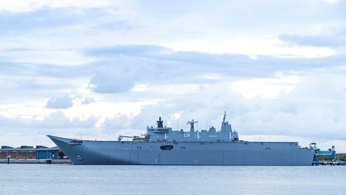 HMAS Adelaide alongside in Brisbane before travelling to Tonga to assist in relief efforts.