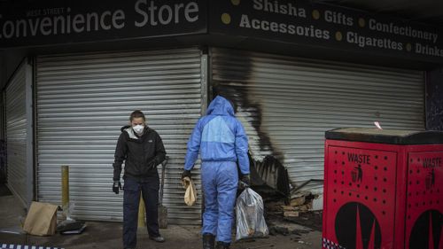 Police and arson investigators on the scene at another Ciggarette store arson attack in West Street, Hadfield. 