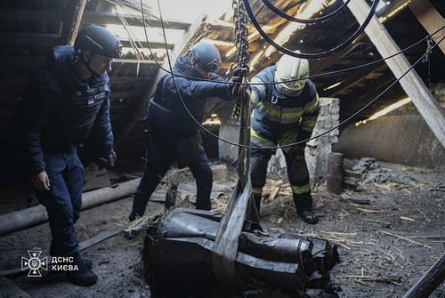 Emergency personnel remove part of a Russian missile that hit an apartment building during a massive rocket attack in Kiev, Ukraine, Sunday, Nov. 17, 2024. 