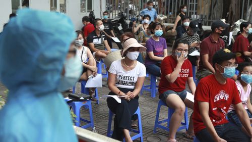 People wait in line for COVID-19 test in Hanoi, Vietnam, Friday, July 31, 2020