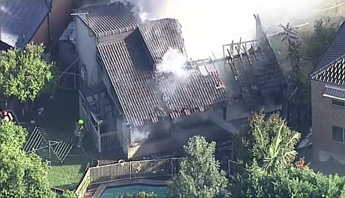 Aerial shots of the house fire shows firefighters hosing down the property as smoke engulfed the home. (9NEWS)