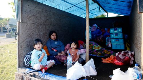 Residents stay at a temporary shelter as they evacuate from a dangerous area. (AAP)