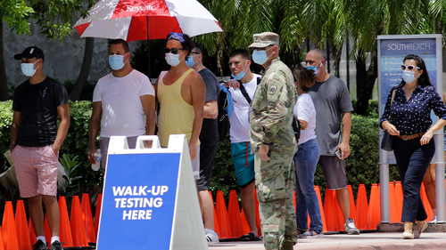 People wait in line at a walk-up testing site for COVID-19 during the new coronavirus pandemic, Tuesday, June 30, 2020, in Miami Beach, Fla. (AP Photo/Lynne Sladky)