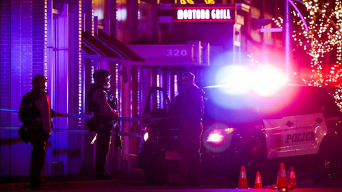 Police stand outside a Lakewood, Colorado, shopping center where the suspected gunman was killed.