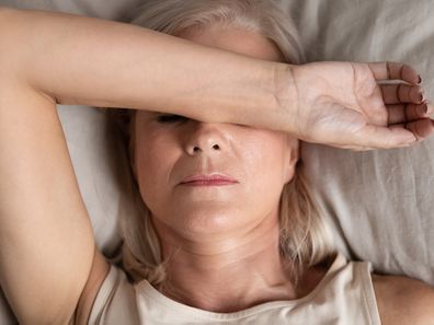 Close up top view middle-aged woman lying down in bed