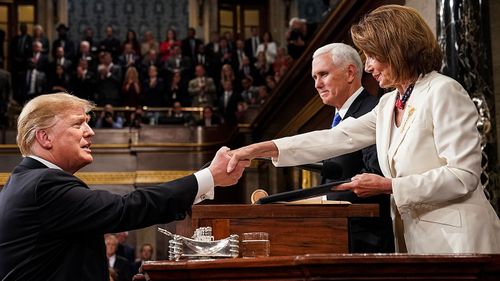 US President Donald J Trump (L) shakes hands with Vice President Mike Pence (C) and Speaker of the House Nancy Pelosi.