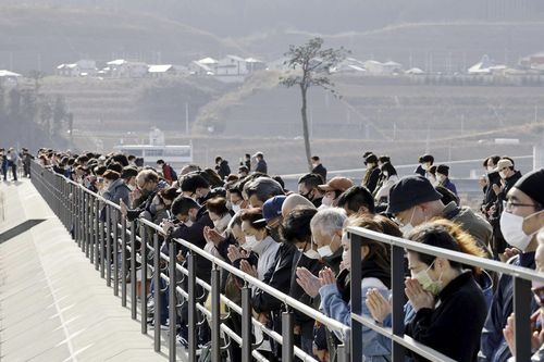 People observe a moment of silence at 2.46pm, the moment the earthquake struck in Rikuzentakata, Iwate prefecture on Saturday, March 11, 2023.  