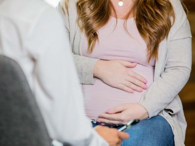 Pregnant woman speaking to healthcare professional.