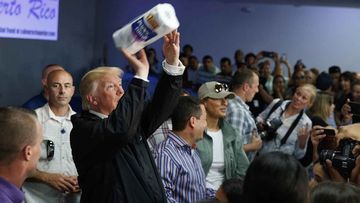 President Donald Trump tosses paper towels into the crowd during his visit to Puerto Rico in the aftermath of Hurricane Maria.