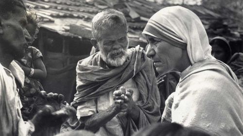 Mother Teresa talks with patients at a leprosy clinic in the 1960s. (AAP)