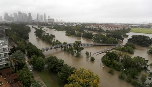 Floodwaters reached the roof lines of single-story homes Monday and people could be heard pleading for help from inside. (AP)