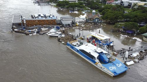 Boats lay wrecked at the Hawethorne Ferry Terminal next to Brisbane City Cats.