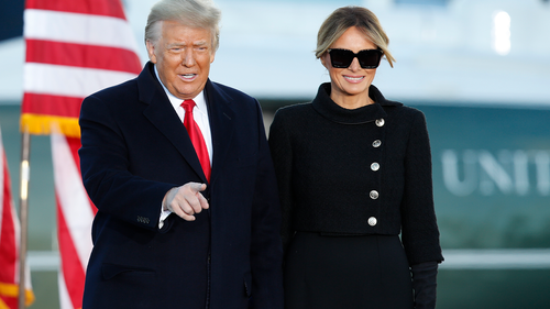 President Donald Trump gestures as first lady Melania Trump looks on before giving a speech to supporters at Andrews Air Force Base, Md., Wednesday, Jan. 20, 2021. (AP Photo/Luis M. Alvarez)