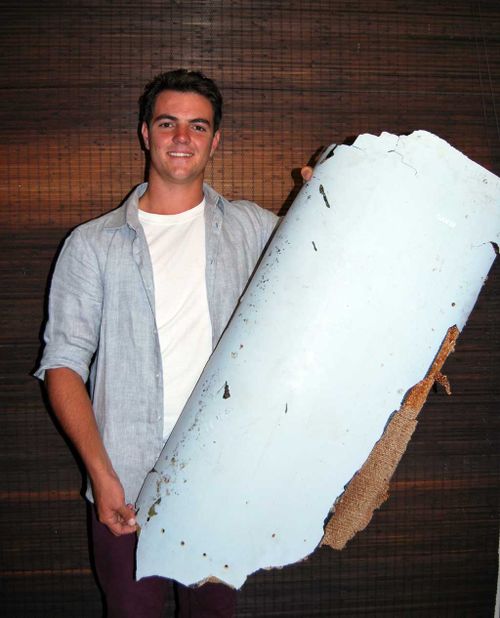 Liam Lotter poses with a piece of debris thought to be part of the missing Malaysia Airlines Flight MH370, in Wartburg. (AAP)