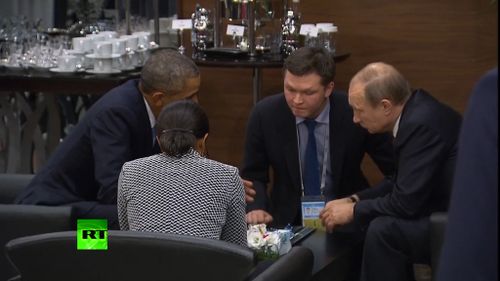 Mr Obama and Mr Putin speak with advisers after the Paris terror attacks.