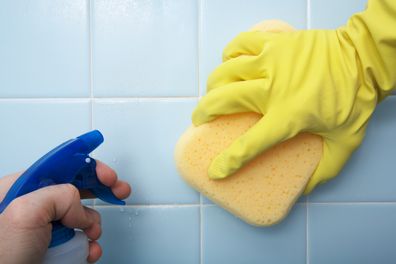 sponge bleach cleaning tiles in bathroom 
