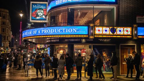 Theatre customers wait to have their Covid-19 passes checked as they queue to see Les Miserables at the Sondheim Theatre in central London.