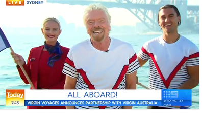 Sir Richard Branson pictured alongside a Virgin Australia and Virgin Voyages employee on Sydney Harbour.