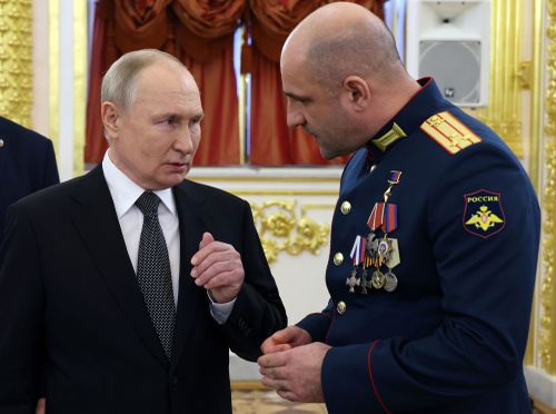 Russian President Vladimir Putin, left, speaks to commander of the reconnaissance battalion "Sparta" Artem Zhoga after a ceremony to present Gold Star medals to Heroes of Russia on the eve of Heroes of the Fatherland Day at the St. George Hall of the Grand Kremlin Palace, in Moscow, Russia, Friday, Dec. 8, 2023. 