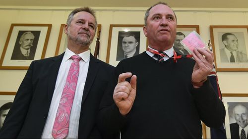 Barnaby Joyce (right) displays his Parliament House visitor's pass with Indigenous Affairs Minister Nigel Scullion. (Image: AAP)