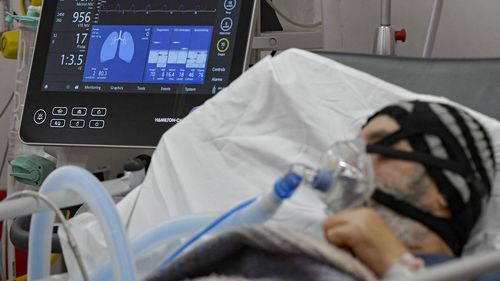 A man breathes through an oxygen mask in the emergency room, turned into a CODIV-19 unit due to the high number of cases, at the Bagdasar-Arseni hospital in Bucharest, Romania, Tuesday, Oct. 12, 2021. (AP Photo/Andreea Alexandru)