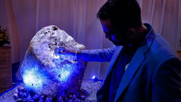 Chamila Suranga, a gemmology researcher attached to Gemological Institute of Ratnapura inspects a 310 kilograms heavy natural corundum blue sapphire at a residence where it is kept in Horana, south of Colombo, Sri Lanka.