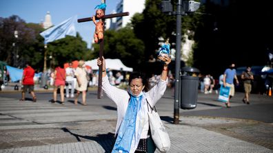 Anti-abortion demonstrator holds a virgin and a bloody baby on a cross outside the National Congress as Deputies vote on a bill to legalise abortion on December 10, 2020 in Buenos Aires, Argentina