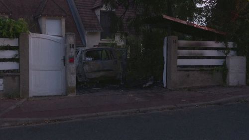 A general view of a burnt car and the damaged residence of Mayor of L'Hay-les-Roses Vincent Jeanbrun, which was ram-raided and set alight while Jeanbrun's wife and children were asleep inside.