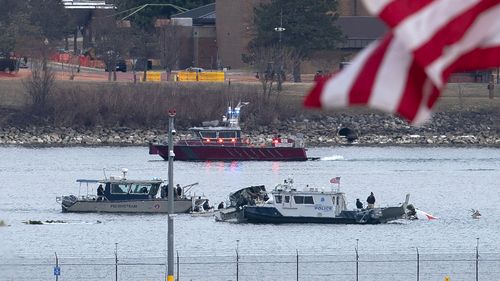 A diving team and police boat is seen around a wreckage site in the Potomac River from Ronald Reagan Washington National Airport, Thursday, Jan. 30, 2025, in Arlington, Va. (AP Photo/Jose Luis Magana)