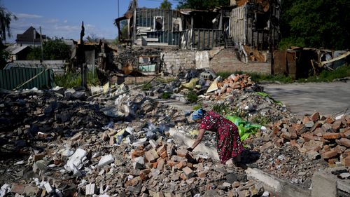 Melania works clearing the rubble of a temple that was destroyed during attacks in Gorenka, on the outskirts of Kyiv, Ukraine, Monday, June 6, 2022. (AP Photo/Natacha Pisarenko)