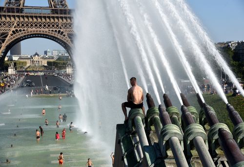 The heat in Paris is forcing people to strip ad jump in the water wherever they can. Image: AAP