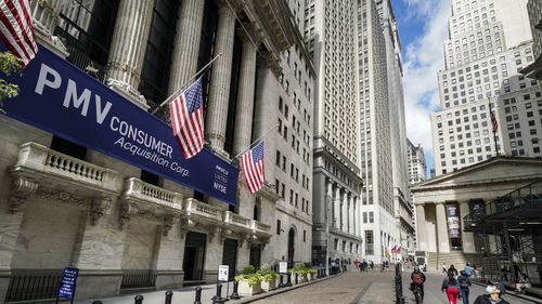 Pedestrians pass the New York Stock Exchange, Friday, Oct. 2, 2020, in New York