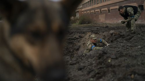 Des policiers ukrainiens collectent des fragments d'un cratère pour déterminer le type de munitions après une attaque russe à Kramatorsk, en Ukraine, le jeudi 29 septembre 2022. (AP Photo/Leo Correa)