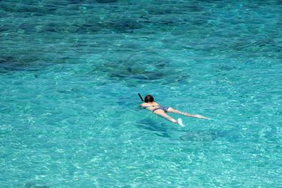 马来西亚停泊岛清水中浮潜的一名年轻女子 库存照片