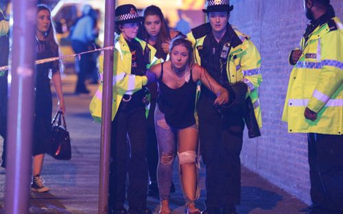 A victim of the suicide bombing at the Ariana Grande concert is led away by emergency workers in Manchester. Photo: Joel Goodman/LNP