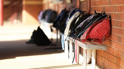 School bags lined up outside classroom.