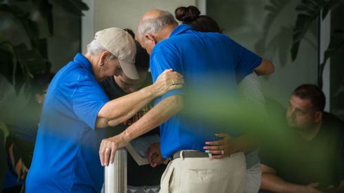 People grieve outside a Hampton Inn &amp; Suites hotel, which turned into a hub for families and friends waiting to hear about loved ones because of its proximity to the medical centre in Orlando. (AP/Loren Elliott)