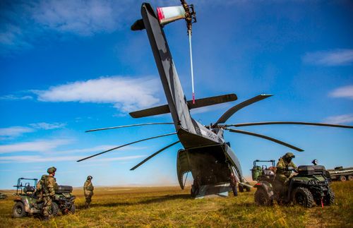 Quad bike-riding soldiers leave a  Russian Mi-26 helicopter in the Vostok 2018 exercises.