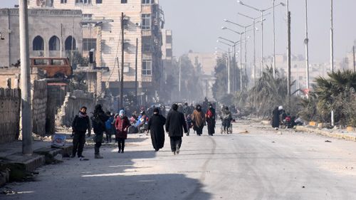 Syrian civilians walk towards a checkpoint manned by pro-government forces, at the al-Hawoz street roundabout, after leaving Aleppo's eastern neighbourhoods on December 10, 2016. (AFP)