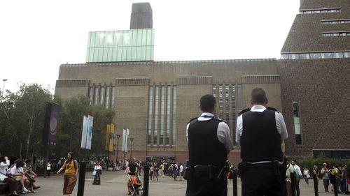 Emergency crews attending a scene at the Tate Modern art gallery, London, Sunday, Aug. 4, 2019. London police say a teenager was arrested after a child "fell from height" at the Tate Modern art gallery.