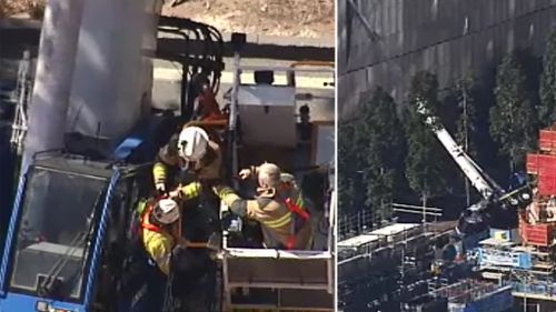 Firefighters pulled a man from the crane's cabin about noon. (9NEWS)