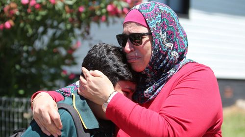 A mother consoles her son whose friend was trapped following the crash. (AAP)