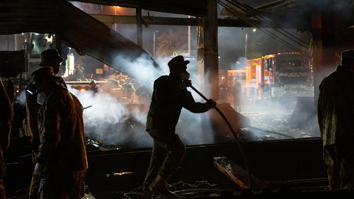 Voluntarii și pompierii Serviciului de Stat de Urgență lucrează pentru a stinge un incendiu într-un centru comercial care a ars după un atac cu rachetă în Kremenchug, Ucraina, marți dimineața, 28 iunie 2022 (AP Photo/Efrem Lukatsky)