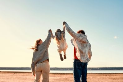 Happy young family with their little beloved daughter playing and having fun outside on their weekend. Family traveling with a child.