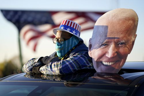 A supporter watches as Democratic presidential candidate former Vice President Joe Biden and former President Barack Obama speak at a rally at Belle Isle Casino in Detroit