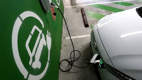A Hyundai Kona Electric charges at a EV charge station
