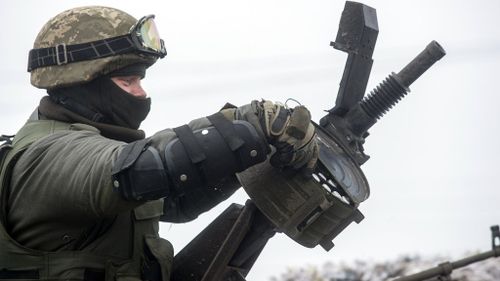 A Ukrainian soldier rides on top of an armoured vehicle to Debaltseve as a column moves near the eastern Ukrainian town of Artemivsk. (Getty)